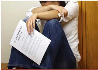 Woman sitting down, crying, holding a document