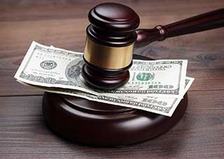 Gavel hitting a stack of hundred dollar bills